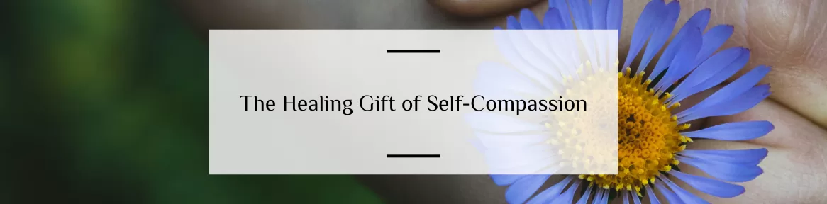hand holding flower with written words of self compassion